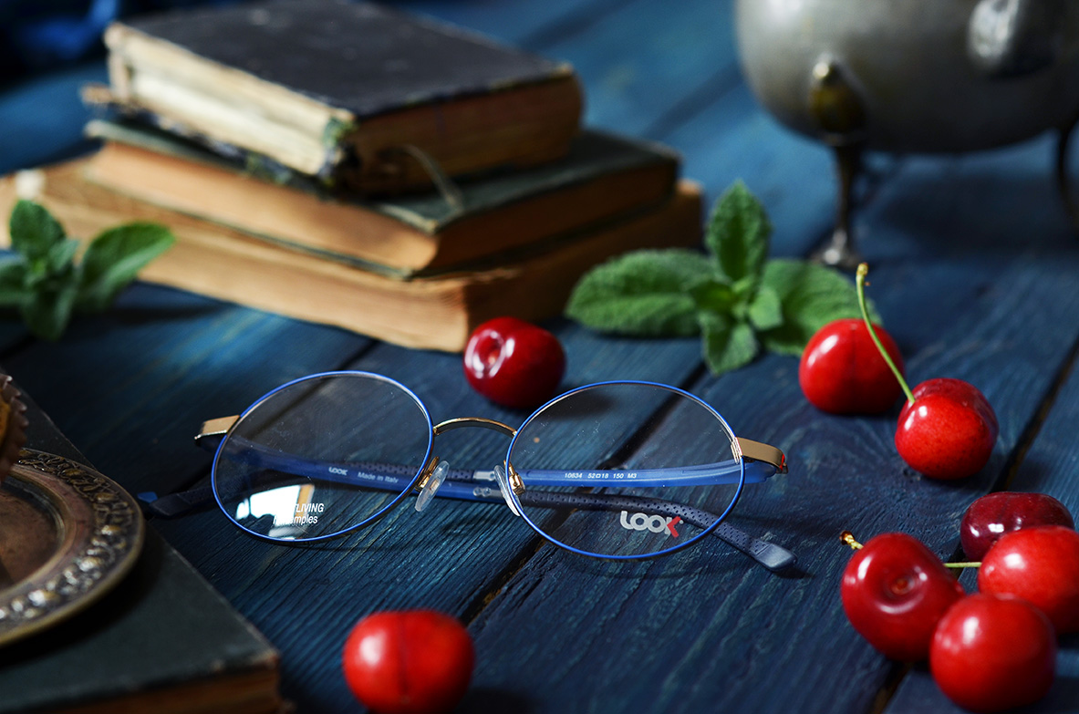 Niebieskie oprawki okularowe w tle wiśnie